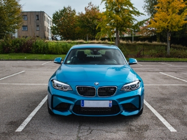 駐車場に停められた青いBMW M2