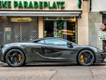 街中のショップ前に停車中のグレーのマクラーレン