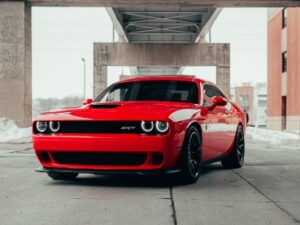 雪の残る路上に停車した赤のダッジチャレンジャー